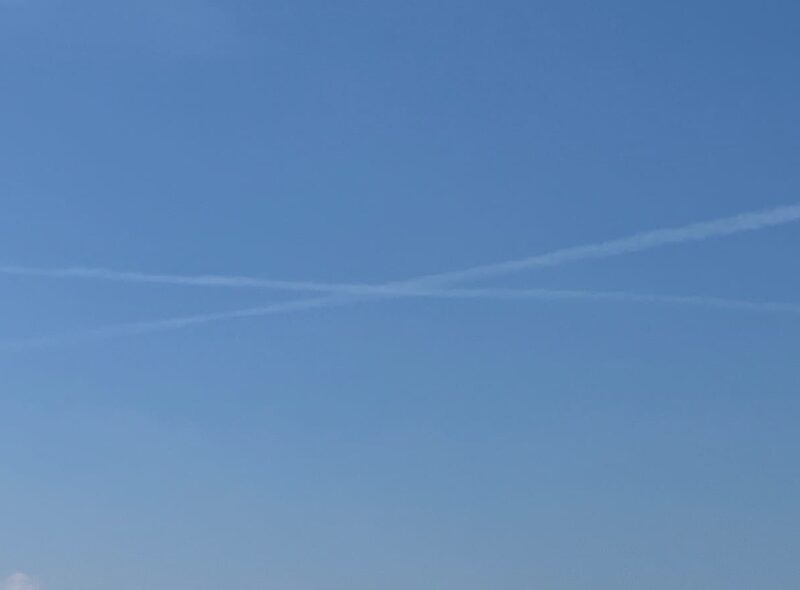 空の写真　夏の雲　画像の中心に大きなバッテン　２本の真っ直ぐな飛行機雲が交差して大きなバッテンに見えるのだ。その画像のバッテン部にもっともっと寄った画像。